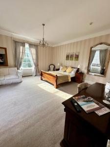 a large bedroom with a bed and a desk in it at Solberge Hall in Northallerton