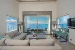 a living room with two couches and a television at Villa Lefkas - Luxury villa Sivota with direct sea access in Sivota