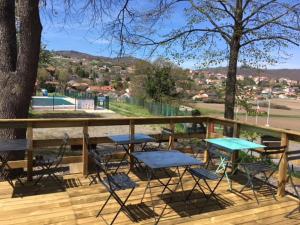 une terrasse avec des chaises, des tables et un arbre dans l'établissement Camping maeva Respire de La Croze, à Châtel-Guyon