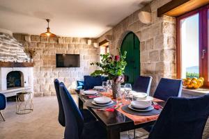 uma sala de jantar com mesa e cadeiras e uma porta verde em 3 bedrooms house with private pool terrace and wifi at Lokva Rogoznica em Lokva Rogoznica