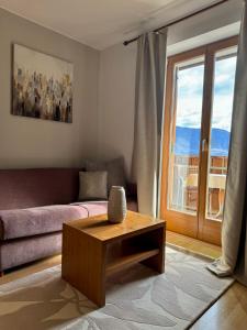 ein Wohnzimmer mit einem Sofa und einem Couchtisch in der Unterkunft Hotel Residence MaVie in Algund