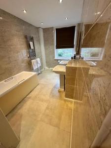 a bathroom with a tub and a sink and a bath tub at Solberge Hall in Northallerton