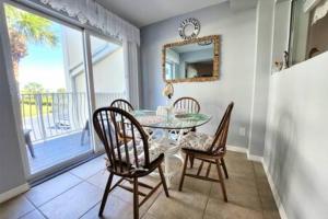 een eetkamer met een glazen tafel en stoelen bij Atrium Oceanview Condo - Sleeps 4 Guests 109 in Cape Canaveral