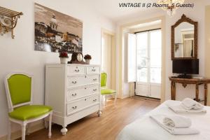 1 Schlafzimmer mit einer Kommode und 2 grünen Stühlen in der Unterkunft Alfama Vintage 1 Ten guests - Alfama Vintage 2 Five guests - Alfama Vintage 3 Three Guests in Lissabon