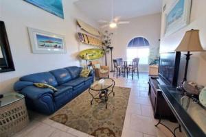 een woonkamer met een blauwe bank en een tafel bij Direct Oceanview Penthouse - Sleeps 6 301 in Cape Canaveral