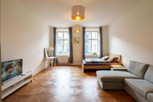 Stay Praha Apartment - New Open! في براغ: غرفة معيشة مع أريكة وتلفزيون