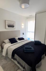 um quarto com uma cama grande e almofadas azuis em Turquesa Del Mar - Max Beach Golf - Ground Floor Apartment em Playa Flamenca