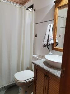 a bathroom with a toilet and a sink at Flor de Loto in Durazno