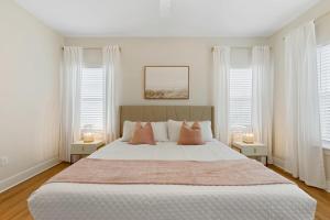 1 dormitorio con 1 cama blanca grande y 2 lámparas en Ocean Breeze- Chic Steps to beach Family Friendly, en St. Augustine