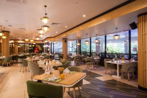 a restaurant with tables and chairs and windows at Eko Hotel Signature in Lagos