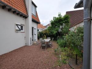 a patio with a table and chairs next to a building at LaTouqu in Le Touquet-Paris-Plage