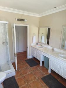 La salle de bains est pourvue de 2 lavabos et d'une douche. dans l'établissement Wave Echo, à Plettenberg Bay