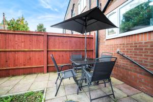 a table and chairs with an umbrella on a patio at Hotel comforts & home conveniences -sleeps 8 in Birmingham