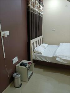a small bedroom with a bed and a night stand at OYO IAE566 Neelkanth Hotel in Rewāri