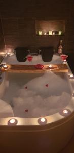 a bath tub with two wine glasses in it at Appart'moderne in Casseneuil