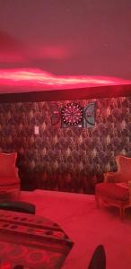 a room with red lighting and a wall with darts at Appart'moderne in Casseneuil