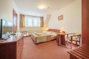 ein Hotelzimmer mit einem Bett und einem Tisch in der Unterkunft Hotel Le Mont Medical & SPA in Świeradów-Zdrój