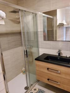 y baño con ducha acristalada y lavamanos. en appartement entre Mer et Corbières, en Cuxac-dʼAude