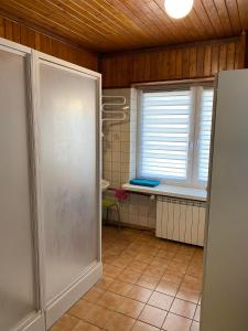 a bathroom with a window and a tiled floor at Pokoje Zielonka in Zielonka
