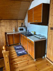 a kitchen with wooden cabinets and a stove top oven at Pokoje Zielonka in Zielonka