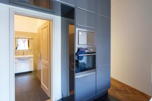 Stay Praha Apartment - New Open! في براغ: مطبخ ازرق مع موقد ومغسلة