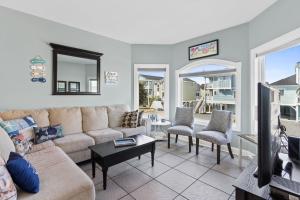 a living room with a couch and a tv at Marsh Mellowed by the Sea Brunswick Vacation Rentals Privated heated pool and beach in Holden Beach