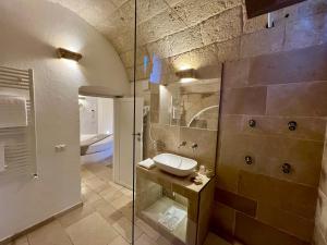 a bathroom with a sink and a glass shower at Vittorio Emanuele Charming Suites in Monopoli