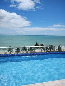 a swimming pool with the ocean in the background at FLAT EM INTERMARES in Cabedelo