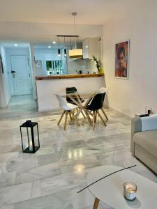 a living room with a table and chairs and a kitchen at 2 Bed Ground Floor Apartment With Pool & Parking in Mijas Costa +19 photos