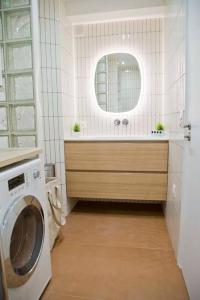 La salle de bains est pourvue d'un lave-linge et d'un miroir. dans l'établissement Luxury Apt Raspail Denfert, à Paris