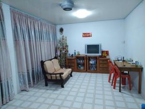 - un salon avec une télévision, une chaise et une table dans l'établissement Sibu Homestay Tekam, à Sibu