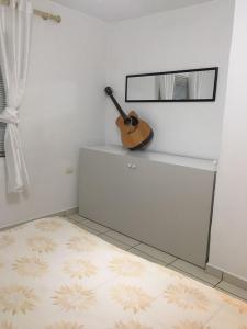 uma guitarra sentada numa prateleira numa sala em Apartment em Shkodër
