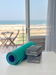 a green rolled up yoga mat on a table with a beach at Ocean Breeze 9 in Sal Rei