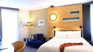 une chambre d'hôtel avec un lit et une chaise bleue dans l'établissement Mercure Hotel Forbach Centre de Loisirs, à Forbach