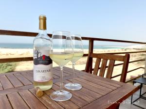 two glasses of white wine sitting on a wooden table at Ocean Breeze 9 in Sal Rei