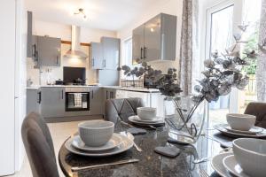 a kitchen and dining room with a table and chairs at Entire 3 bedrooms home away from Home in Salford in Manchester