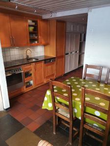 uma cozinha com armários de madeira e uma mesa e cadeiras em Stor super leilighet - bakkeplan - barnevennlig - 80m2 - selvhushold - vaskefirma em Hovden