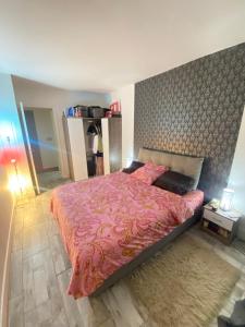 um quarto com uma cama grande e um cobertor rosa em The Place to Be em Le Blanc-Mesnil