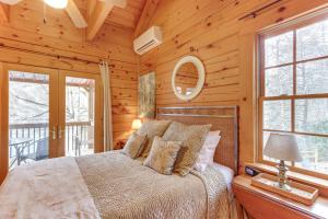a bedroom with a bed in a log cabin at Toccoa Waterfront Hideaway Hot Tub and Fire Pit! in Mineral Bluff