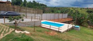 uma piscina num quintal com uma cerca em Chácara Tranquila Pouso Alegre em Pouso Alegre