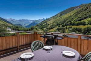a table on a balcony with a view of mountains at Chalet Bon Amour in Saint-Sorlin-dʼArves