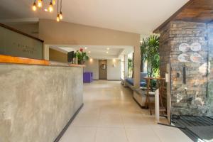 a lobby of a restaurant with a stone wall at Hotel Barra da Lagoa by Latitud Hoteles in Búzios
