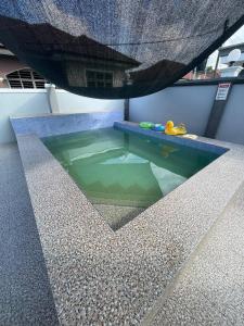 a swimming pool in the middle of a building at Homestay PCB Villa MamaKaya in Kota Bharu