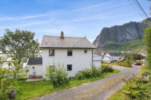 a white house on the side of a road at Reine Fishermans House - Mountain & Seaview in Reine