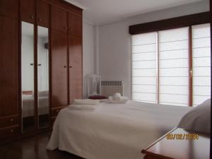Un dormitorio con una cama blanca y una ventana grande. en OLIVO 75, en Leza 2 fotos más