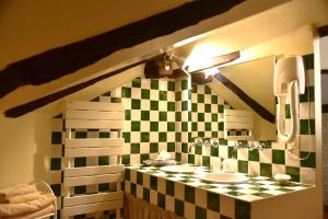 a bathroom with two sinks and a checkered wall at Le Clement V in Belvès