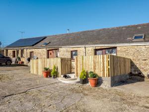 a house with a fence and potted plants in front of it at 1 bed in Brynteg 87362 in Llanwenog