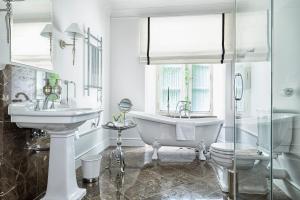 a white bathroom with a tub and a sink and a bath tub at Zamek Janów Podlaski in Janów Podlaski