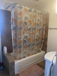 a bathroom with a shower curtain with shells at Appartement près du Métro in Laval