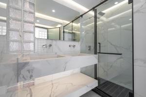 a bathroom with two sinks and a glass shower at Molly Homestay - Nanjing East Road the Bund 3-Bedroom with Elevator Apartment in Shanghai